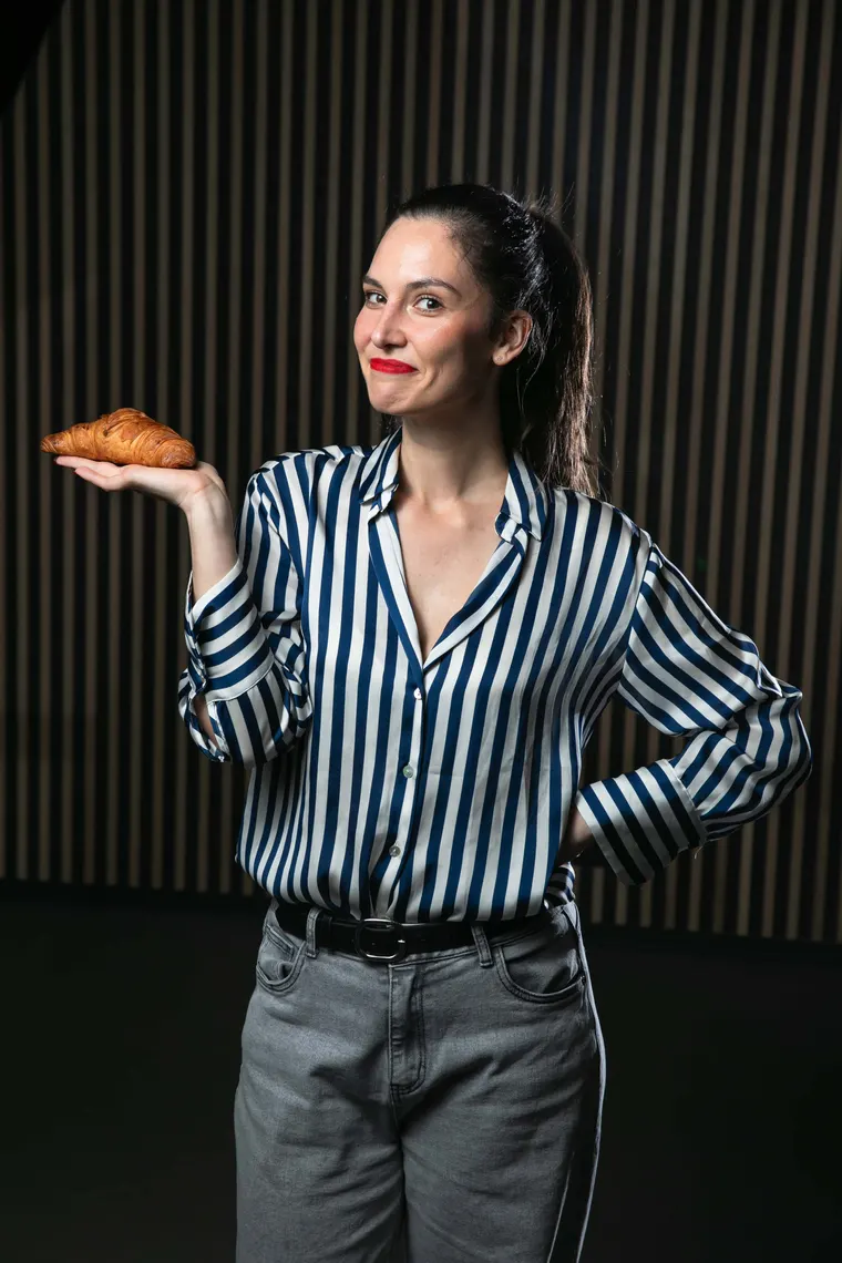 Tess offering a croissant on her open palm