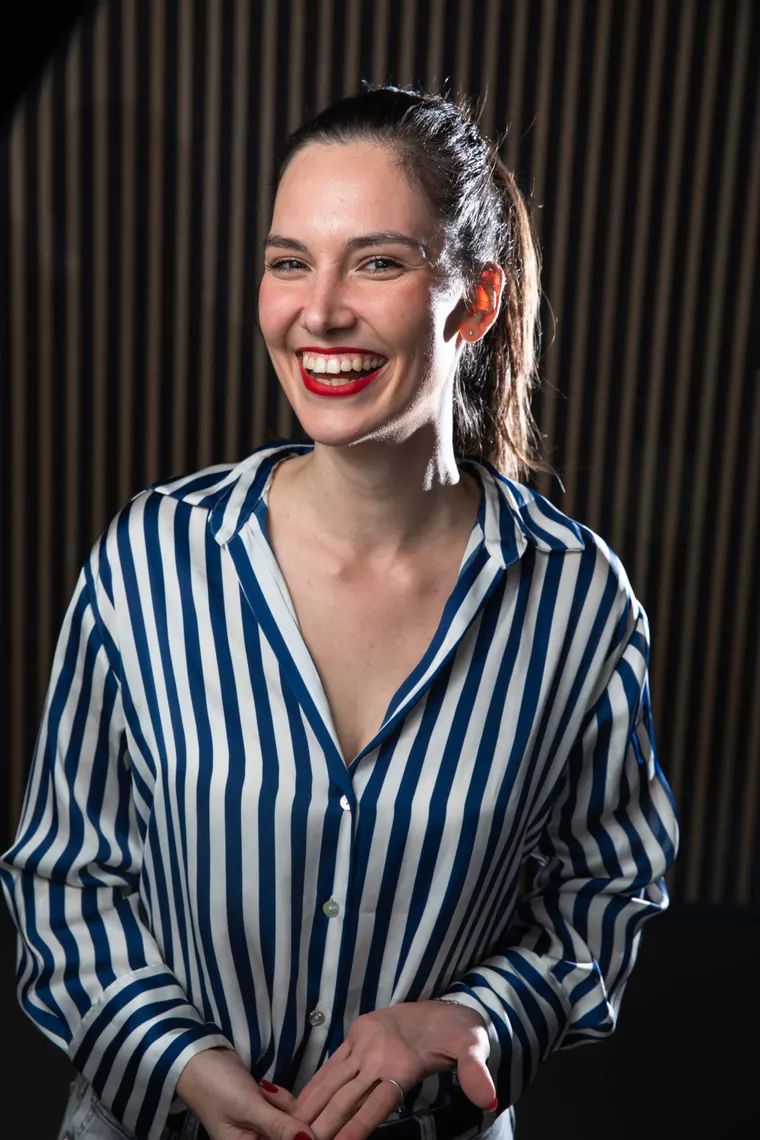 Tereza, the French teacher behind FrenchTess, smiling with her hands together