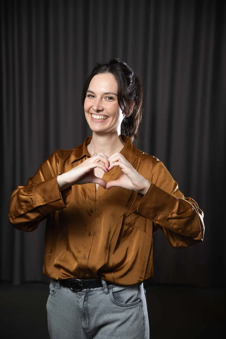 Tess making a heart with her hands